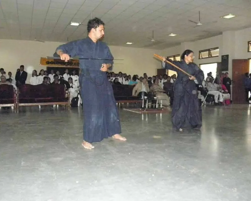 A man with a katana and a woman with a wooden bokken performing in hakama